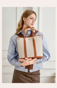 Canvas and leather tote bag with vertical design, large capacity and stylish handles for daily use.