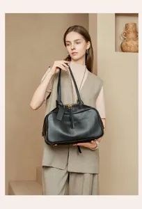 Detailed view of black leather Boston shoulder bag held by model, showcasing premium commuter style.
