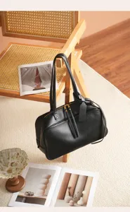 Detailed view of the black leather Boston bag showcasing premium texture and fine stitching.
