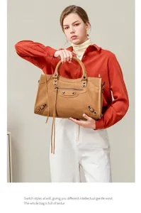 Stylish brown suede motorcycle handbag for women with classic metal studs and tassel details.