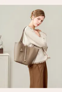 Detail view of stylish genuine leather bucket shoulder bag in elegant gray color with lock.