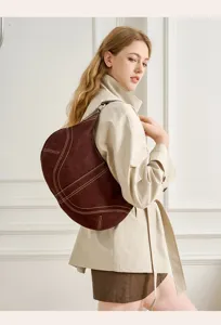 Vista dettagliata della borsa hobo marrone in pelle con cuciture a contrasto e modella.
