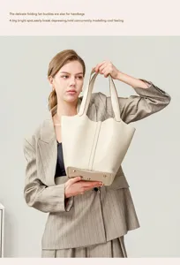 Detailed view of the genuine leather bucket handbag with metal feet and handle design.