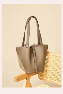 Detailed view of the genuine leather bucket handbag showcasing fine texture and premium hardware.