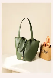 Green genuine leather bucket handbag detail view, premium pebbled texture with metal lock decor.