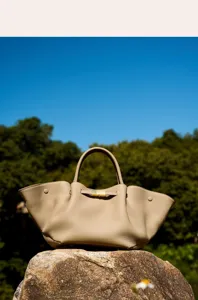 Detailed view of the stylish khaki leather shoulder bag with structured design and gold lock.