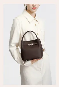 Detailed view of a stylish dark brown genuine leather handbag featuring a metal turn-lock.