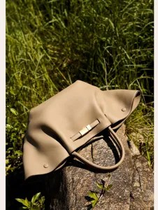 Detail shot of the luxurious genuine leather tote bag in taupe, highlighting soft texture.