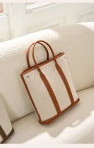 Vertical canvas tote bag with brown leather trim, large capacity stylish handbag for women.