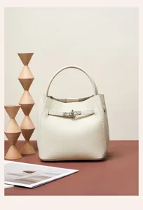 Detailed view of luxury leather bucket bag with elegant metal lock closure and pebbled texture.