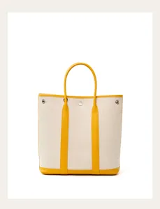 Canvas tote bag with yellow leather handles and trim, spacious vertical design for daily use.