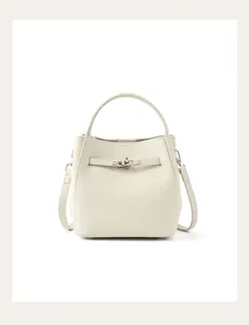 Leather bucket bag detail showing the metal lock closure and premium pebbled leather text.