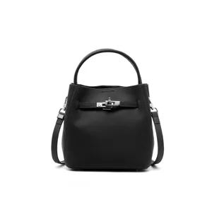 Detailed view of black leather bucket bag with metal lock closure and adjustable strap.