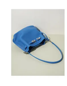 Blue pebble leather bucket bag detail view, stylish shoulder bag with metal lock hardware.
