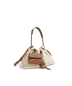 Canvas and leather detail showing the chic drawstring design and front pocket of the bag.