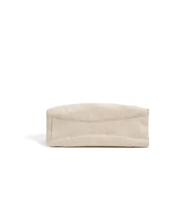 Detail view of the beige canvas bag bottom, showing fine stitching and premium fabric texture.
