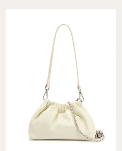 Primo piano della borsa a soffietto in pelle crema con catena d'argento e teschio.