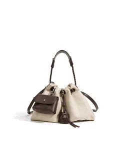 Detailed view of chic canvas bucket shoulder bag with brown leather straps and pouch.