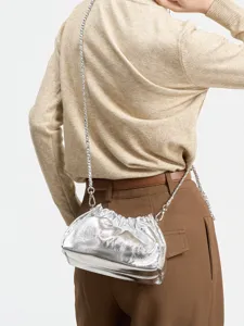 Borsa a tracolla argentata arricciata effetto nuvola con catena indossata da modella.