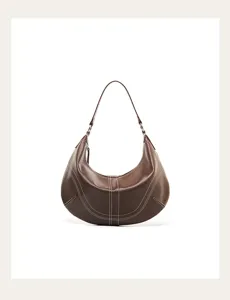 Dettaglio in primo piano della borsa a spalla hobo in pelle marrone con cuciture.