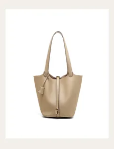 Detailed view of genuine leather bucket bag, showing premium texture, metal lock, and smooth finish.