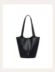 Black leather bucket bag detail view, premium pebbled cowhide texture with gold tone padlock.
