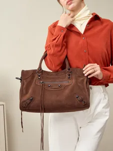 Stylish brown suede motorcycle handbag for women, chic shoulder bag with tassels and zippers.