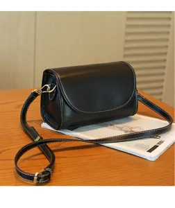 Black vintage leather crossbody bag detail, genuine cowhide shoulder bag with contrast stitching.