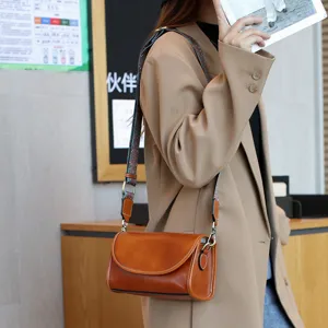 Vintage genuine leather shoulder bag for women, retro crossbody bag with wide strap.