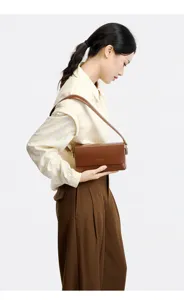 Close-up detail view of the brown leather shoulder bag showcasing fine stitching and hardware.