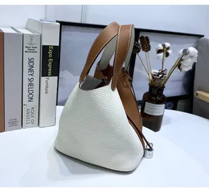 Two-tone genuine leather bucket bag chic handbag with top handles and mini padlock charm.