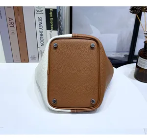 Genuine leather bucket bag bottom detail with sturdy metal protective feet and fine craftsmanship.