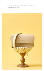 Detail view of minimalist beige shoulder bag, featuring elegant flap design and golden hardware.