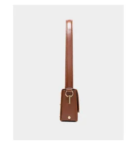 Side detail view of the brown leather minimalist small square shoulder bag with fine metal hardware.