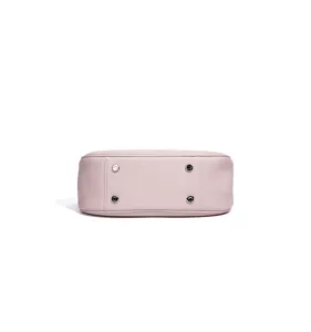 Gros plan sur le fond du sac à main en cuir rose avec quatre pieds de protection.