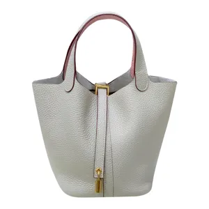 Genuine leather bucket bag for women, stylish handbag with pink interior and lock.