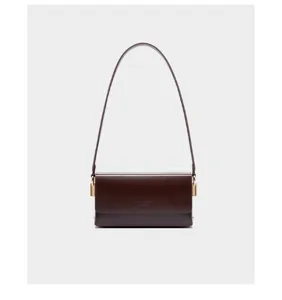 Minimalist dark brown leather shoulder bag detail, elegant underarm bag with gold hardware.