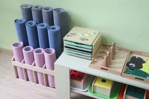 Montessori wooden rug stand and educational toy storage shelf for early childhood learning.