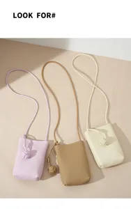 Detail view of small leather phone bags with delicate knot decor, elegant crossbody style.