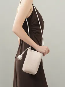 Minimalist vertical leather cell phone bag for women, chic crossbody bag with knot strap design.