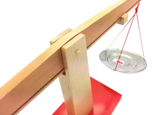 Wooden Montessori balance scale toy detail view showing wooden beam and scale pan.