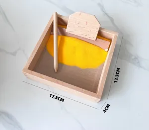 Montessori wooden sand scraping box detail, wooden stylus and yellow sand for early learning.
