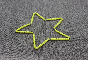Vue détaillée de perles de mathématiques jaunes liées en étoile pour l'éducation.