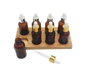 Amber glass dropper bottles set with wooden stand detail view, essential oil bottle display.