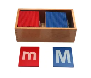Detailed view of Montessori wooden box with red and blue sand letters for early childhood education.
