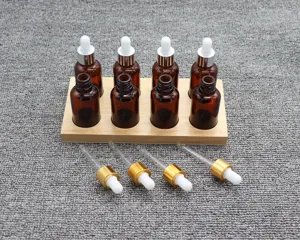 Set of amber glass dropper bottles with wooden display stand, ideal for sensory training.