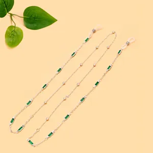Detailansicht der eleganten silbernen Brillenkette mit grünen rechteckigen Steinen für Damen.