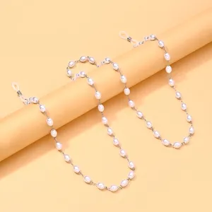 Nahaufnahme der eleganten Perlen-Brillenkette mit sicheren Silikonringen und goldenen Gliedern.