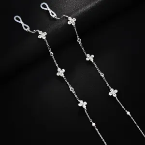 Detailaufnahme einer silbernen Kristall-Kleeblatt-Brillenkette mit Perlen und Silikonringen.