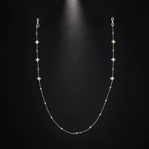 Goldfarbene Brillenkette mit Perlenakzenten, elegante lange Kordel als Detailansicht.